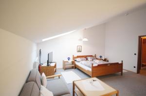 基姆高地区阿绍Gschwendtnerhof的一间卧室配有一张床和一张沙发