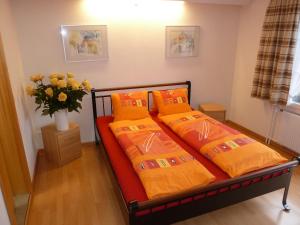 阿峙奇Hotel Restaurant Sunnmatt的一间卧室配有两张带橙色床单和花瓶的床。