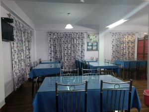 噶伦堡Aapas Residency的一间设有蓝色桌椅和窗帘的用餐室
