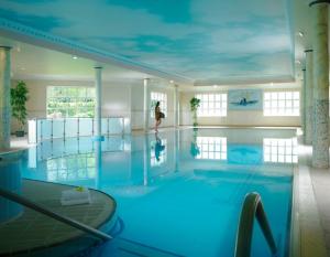 塔洛沃尔斯利山酒店&高尔夫度假胜地的一个大型游泳池,一个女人站在水里