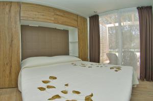 诺维格勒伊斯特拉里维埃拉活动房屋假日公园的一间卧室,床上有床,上面有树叶