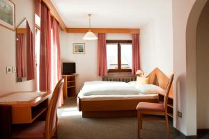 拉松迪索帕拉加尼冷泽勒住宿加早餐旅馆的一间卧室配有一张床、一张桌子和一张书桌