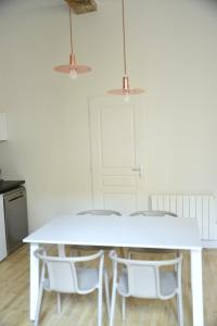 里昂Cosy apartment ideally located in the Old Town的白色的餐桌,两把椅子和两盏灯