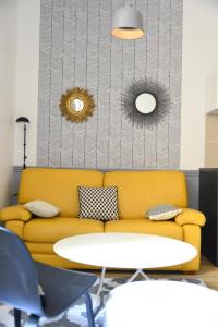 里昂Cosy apartment ideally located in the Old Town的一张黄色的沙发和一张桌子
