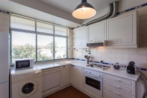 特罗亚Moradia T3 Soltroia Mar的厨房配有白色橱柜、洗衣机和烘干机