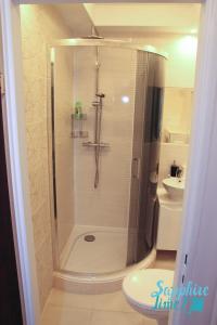 罗兹Apartment Sapphire Time的带淋浴、卫生间和盥洗盆的浴室