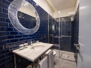 波尔图阿尔克凯里公寓的蓝色瓷砖浴室设有水槽和镜子