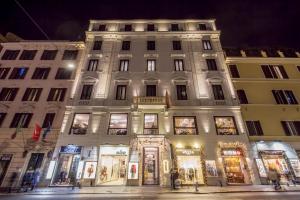 罗马Hotel 87 eighty-seven - Maison d'Art Collection的一座白色的大建筑,晚上有商店前