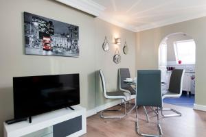 伦敦2Bed 2Bath Apartment in Fitzrovia - FREE Exclusive Parking的客厅配有电视和桌椅
