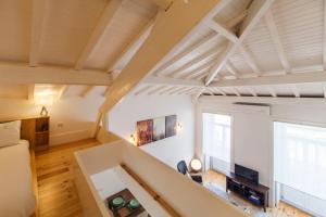 波尔图Oporto Mezzanine - by ML Apartments的大型客厅拥有白色的墙壁和木制天花板。