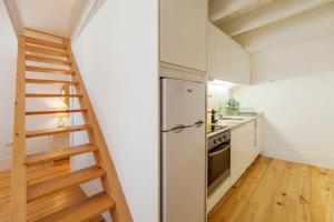 波尔图Oporto Mezzanine - by ML Apartments的厨房设有冰箱旁的楼梯