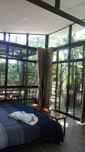 Ban Muang Chum班莱克莱昂民宿的一间卧室设有一张床和一个大窗户