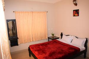 科代卡纳尔SkyHighVilla的一间卧室配有一张带红色毯子的床和窗户。