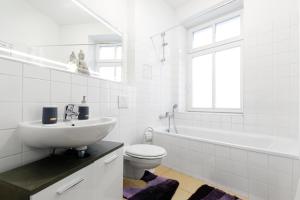 柏林中央米特公寓 的白色的浴室设有水槽、卫生间和浴缸。
