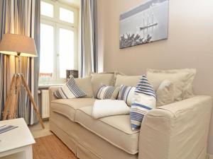 奥斯赛拜-塞林Villa Fernsicht - Apt. 06的客厅配有白色沙发,提供蓝色和白色枕头