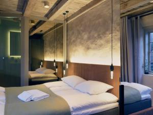 克拉格勒Tollboden Hotell - Unike Hoteller的一间卧室配有两张带白色枕头的床