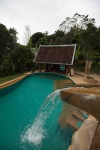 琅勃拉邦Shangri-Lao Resort的一座游泳池,其建筑背景为: