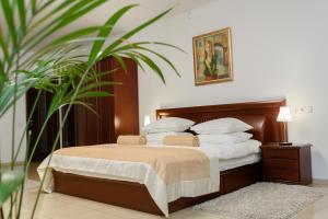 苏梅M&M公寓式酒店的一间卧室配有带白色枕头和植物的床