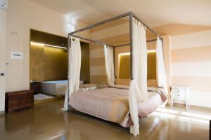 代森扎诺-德尔加达Alessi Hotel Trattoria的一间卧室配有一张天蓬床和一个浴缸