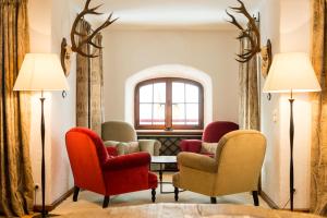 滨湖采尔Schloss Prielau Hotel & Restaurants的一间设有椅子和桌子的等候室和窗户