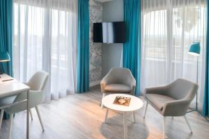 圣艾格夫Van der Valk Hotel Saint-Aygulf的客厅配有两把椅子和一张桌子
