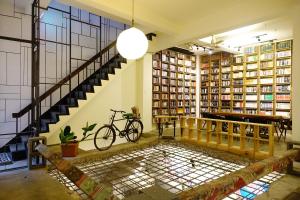 台南艸祭Book inn旅舍的图书馆里的一个房间,有楼梯和自行车