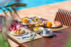 圣塔艾格尼丝科罗纳Hotel Rural Can Pujolet的餐桌上摆放着早餐食品和橙汁