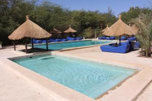Ndangane莱斯科登斯布罗伊斯酒店的一个带蓝色椅子和遮阳伞的游泳池