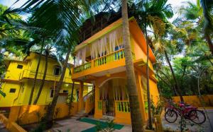 莫尔吉姆Orange Villa的一座棕榈树的黄色建筑