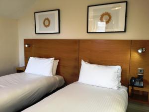 洛西茅斯斯托特菲尔德的配有白色床单的酒店客房内的两张床