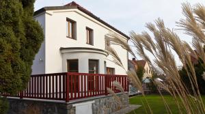 赫鲁迪姆Residence Arx & Wellness的白色的房子,有红色的围栏和棕榈树