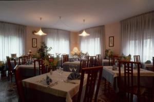 阿尔塔泰尔梅Albergo Miramonti的用餐室设有桌椅和窗户。