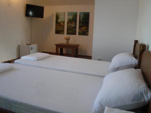 苏恰瓦Casa Hora的配有白色床单的客房内的两张床