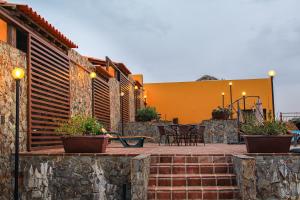 EsperançaMonte da Esperanca的一座带桌椅的庭院和一座黄色的建筑