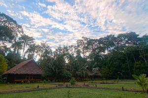 马尔多纳多港Amazon Field Station byInkaterra的云天的田野中的小屋