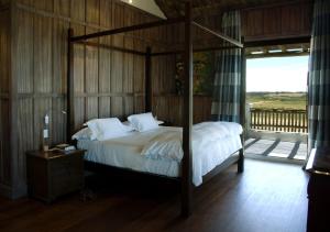 何塞伊格纳西奥何塞伊格纳西奥埃斯坦西亚维克酒店的一间卧室配有一张带木墙的天蓬床。