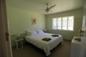 金皮CedarBrae Country Stay的一间卧室配有一张带白色床单的床和一扇窗户。