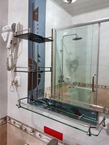 基加利诺布莱扎酒店的浴室设有玻璃淋浴间和镜子