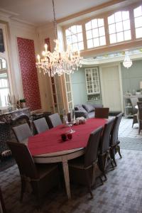 伊普尔La Porte Cochère的一间用餐室,配有红色的桌子和椅子
