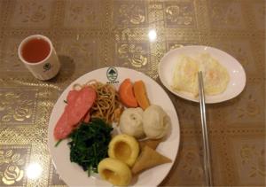 汶上格林豪泰山东省济宁市汶上县宝相寺快捷酒店的餐桌,带两盘食物和一杯茶