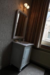 伊普尔La Porte Cochère的一间带水槽和镜子的浴室以及窗户。