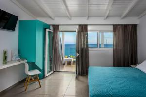 依拉佩特拉Coral Hotel的一间配备有蓝色床的卧室,享有海景