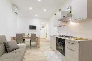 陶尔米纳Dreaming Taormina Apartment的厨房以及带沙发和桌子的客厅。