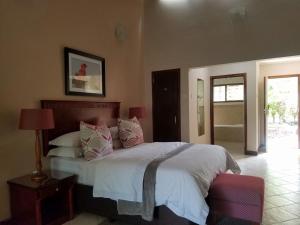 利隆圭Ufulu Gardens Hotel的一间卧室配有带白色床单和粉红色枕头的床。