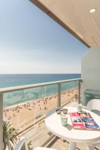 布拉内斯布拉内斯海滩皮埃尔假日公寓的阳台配有桌子,享有海滩美景
