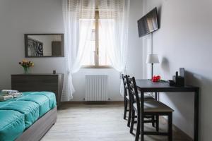 博洛尼亚Il Filo di Arianna的一间卧室配有桌子、床和书桌