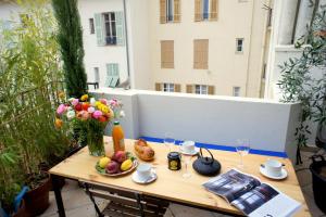 尼斯Ze Perfect Place - Élégant appartement avec terrasse - Promenade des Arts的阳台上的桌子上摆放着水果和鲜花