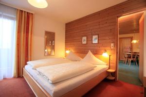 蒂罗尔-基希贝格霍尔罗斯酒店的一间卧室设有一张带木墙的大床