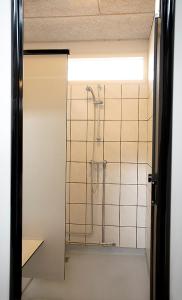 Nivå尼瓦露营别墅酒店的带淋浴的浴室和玻璃门