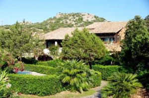 罗通多港Rotondo Residence - Simar Vacanze的一座带树木和灌木的花园的房子